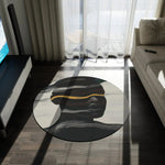 Waves of Identity Round Rug on dark wood floor in a sunlit room, abstract face with white wave lines and gold band visible
