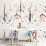 Whimsical Enchanted Forest wallpaper of deer and owls in bare trees behind a white kids' desk