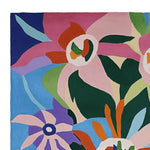 Colorful abstract design on a square area rug, featuring large floral patterns in vibrant hues of pink, blue, green, and orange. This hand-tufted wool rug is perfect as a contemporary rug for large living rooms, adding a whimsical touch to your decor.