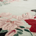 Close-up of a floral patterned rug with pink flowers and green leaves.