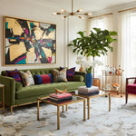 Living room with a green sofa,  chinoiserie modern rug, colorful pillows, and a large abstract painting on the wall.