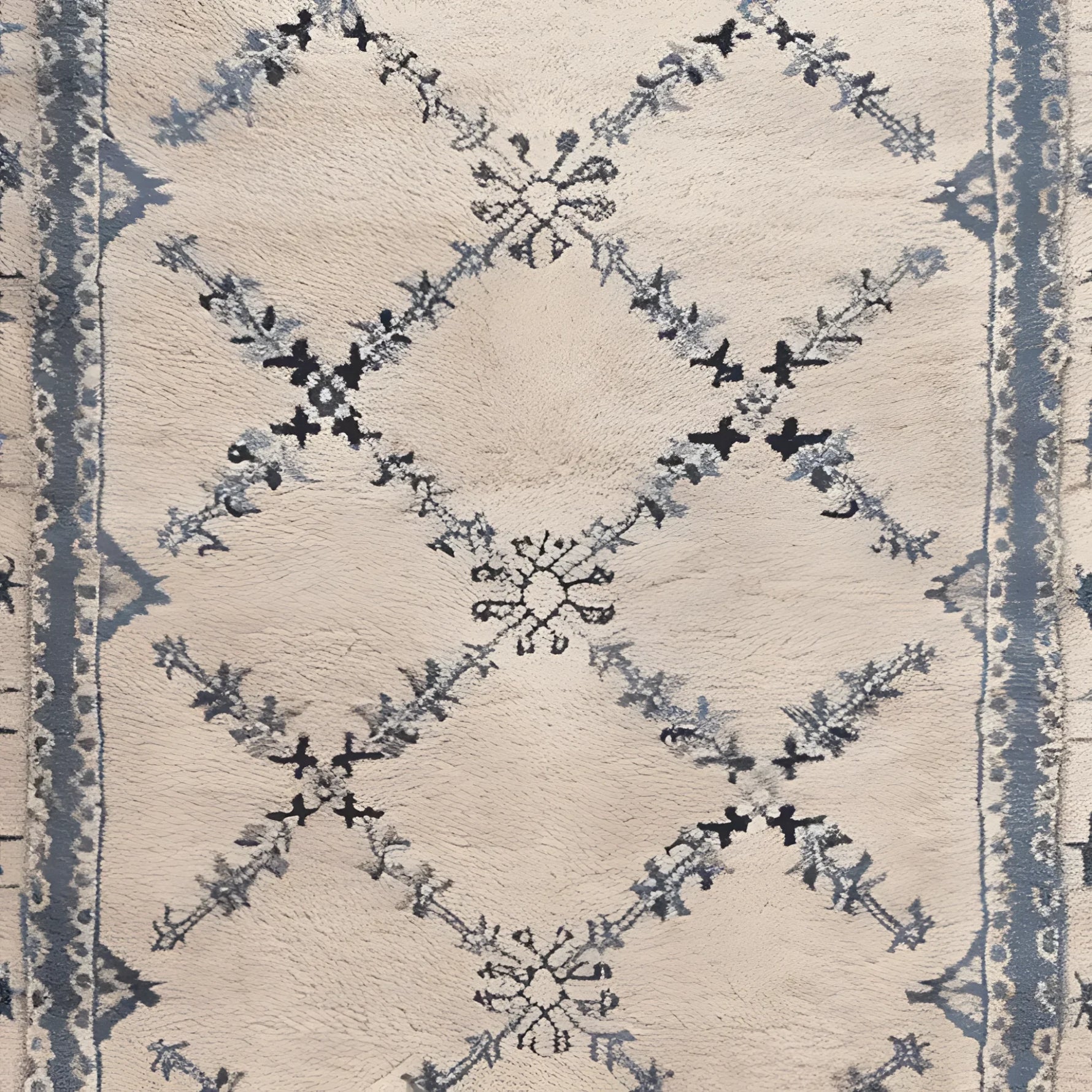 Close-up of the Whispering Vines Hand Knotted Rug, showcasing its intricate wool design with blue and black vine patterns on a cream background. Perfect as an area rug, this vintage-inspired piece is ideal for adding elegance to living room spaces.