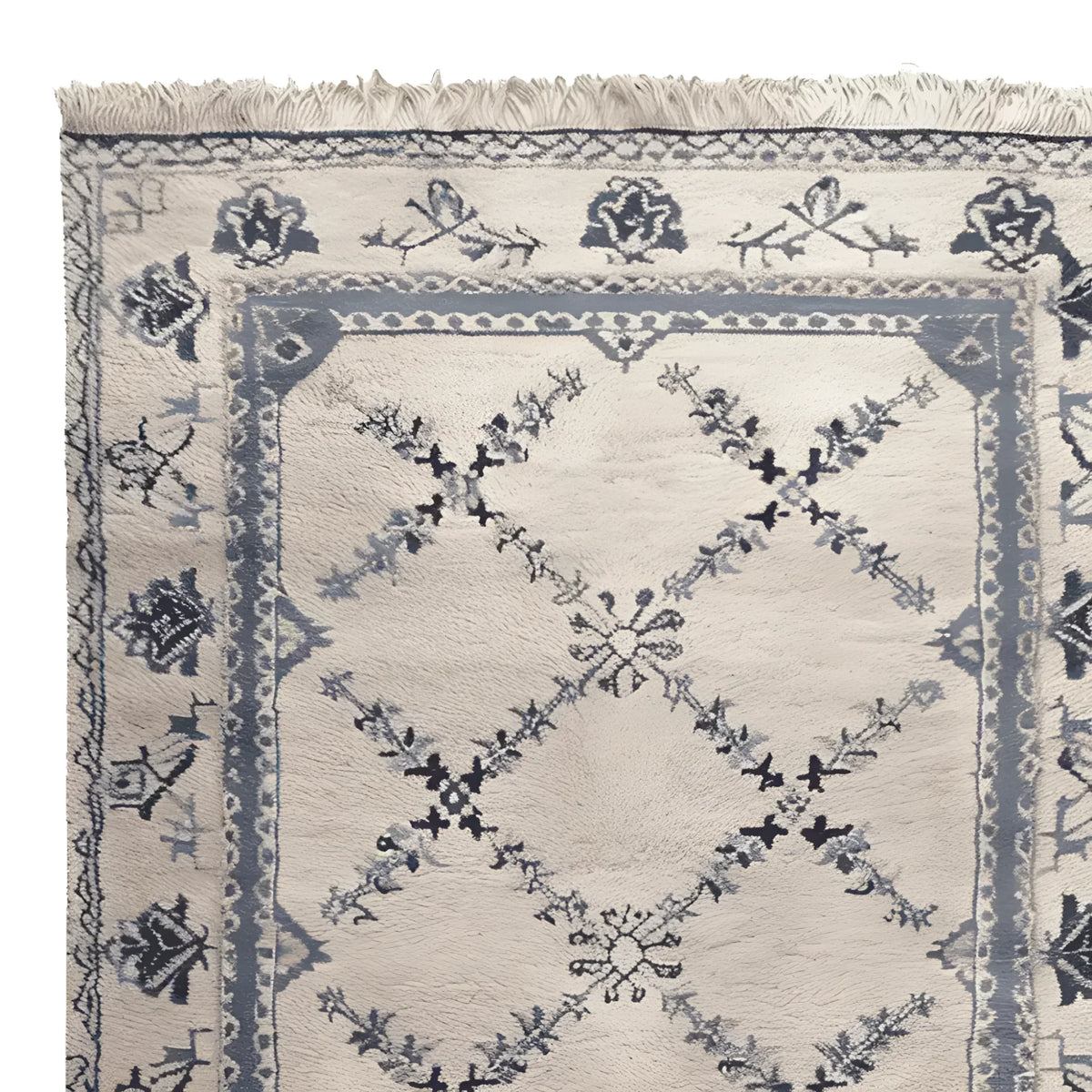 Close-up view of the Whispering Vines Hand Knotted Rug, showcasing its intricate floral and geometric patterns. This wool area rug, perfect for living rooms, features a vintage design in soft blue and cream tones, exemplifying elegance and sophistication.