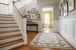 Staircase in a home with decorative rug and framed pictures on the wall.