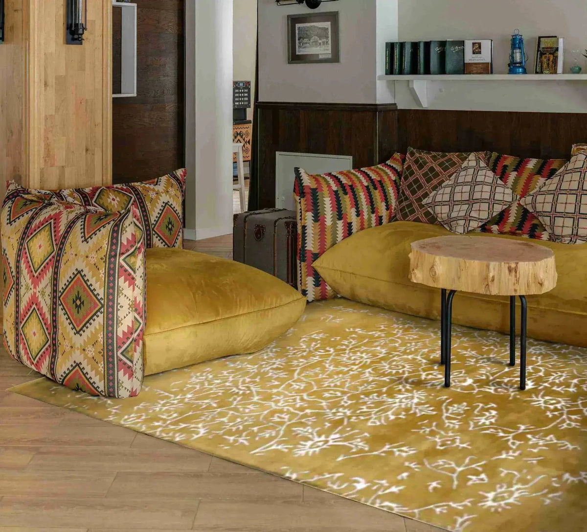 This elegant area rug, titled 'White Bloom Elegant Hand Tufted Viscose Rug - Golden', graces a stylish living room setting. Its intricate patterns and golden hues provide a vintage charm, making it an ideal choice for large living room rugs. Perfect for adding warmth and sophistication, this wool rug complements the vibrant cushions and natural wood accents, creating a cozy and inviting space.