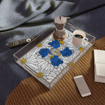 Daisy ladies in blue acrylic tray on a round jute rug — moka pot and coffee cup, navy linen, books