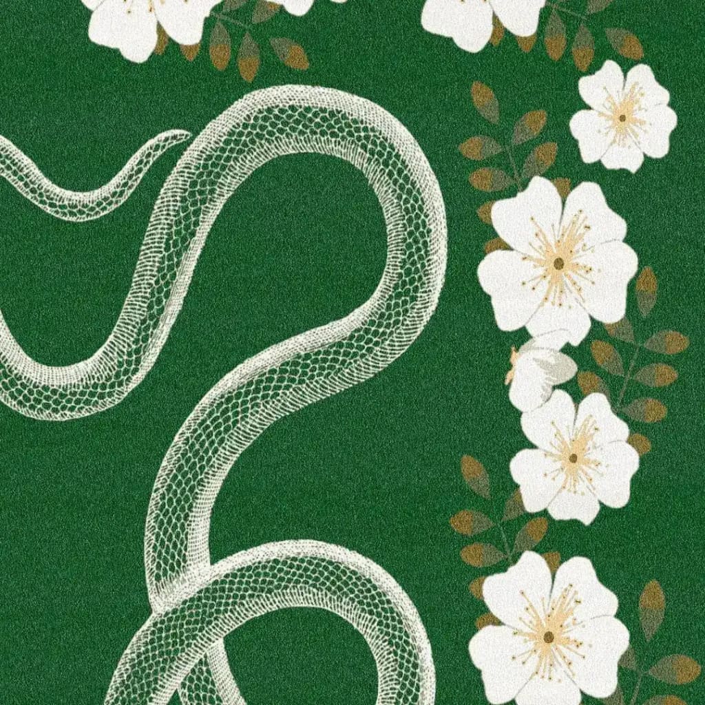 A vibrant hand-tufted wool rug featuring a striking design of white flowers and a snake on a lush green background. Perfect for adding a touch of boho style to large living rooms or bedrooms, this area rug combines elegance and nature-inspired motifs.