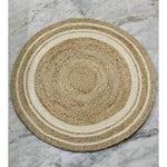 A beautifully hand-braided round jute rug with white trim, perfect for adding a boho touch to any dining room. This natural area rug features intricate weaving that complements formal dining room settings and enhances the cozy vibe of your space.