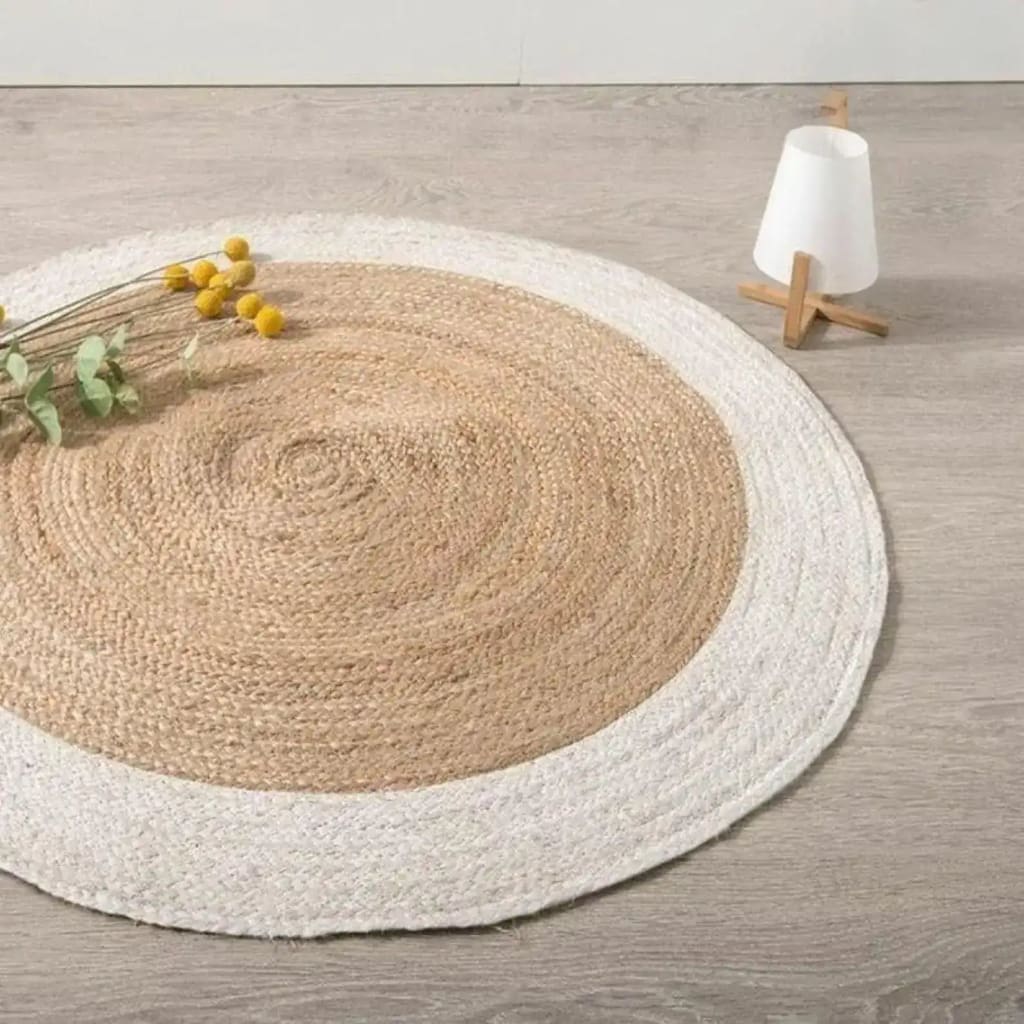 A stylish area rug featuring a round jute design with a white trim, placed on a light wooden floor. Perfect for adding a natural touch to offices or dining rooms, this round rug enhances any space with its earthy texture and modern look.