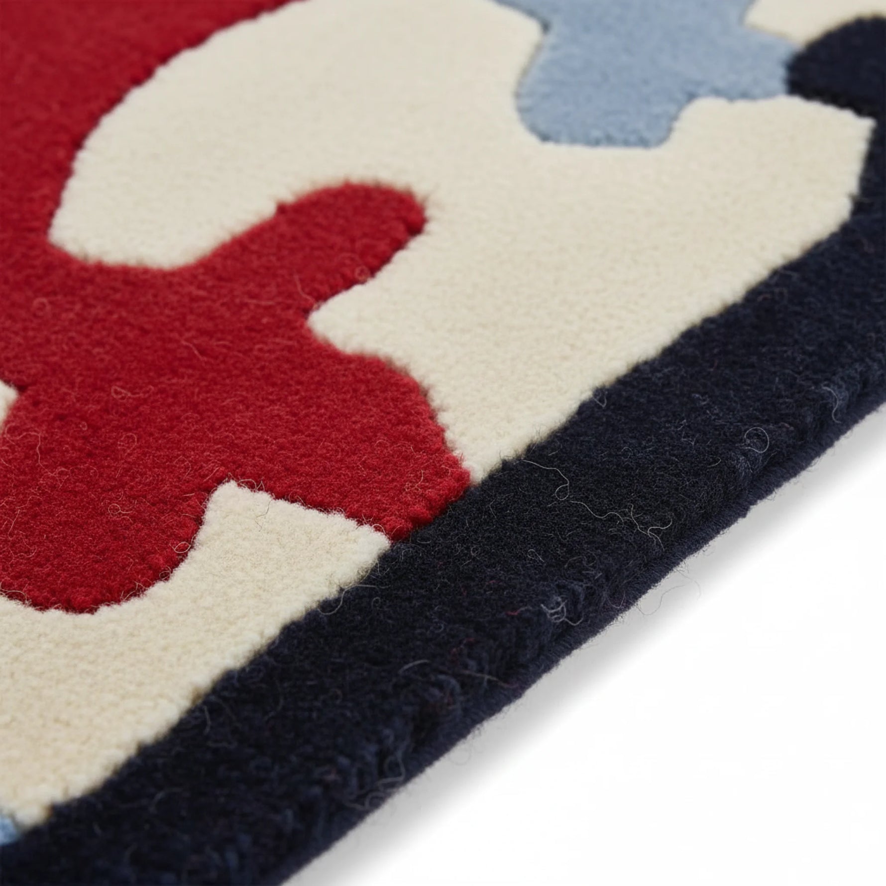 Close-up of a colorful children's rug with geometric patterns on a white background