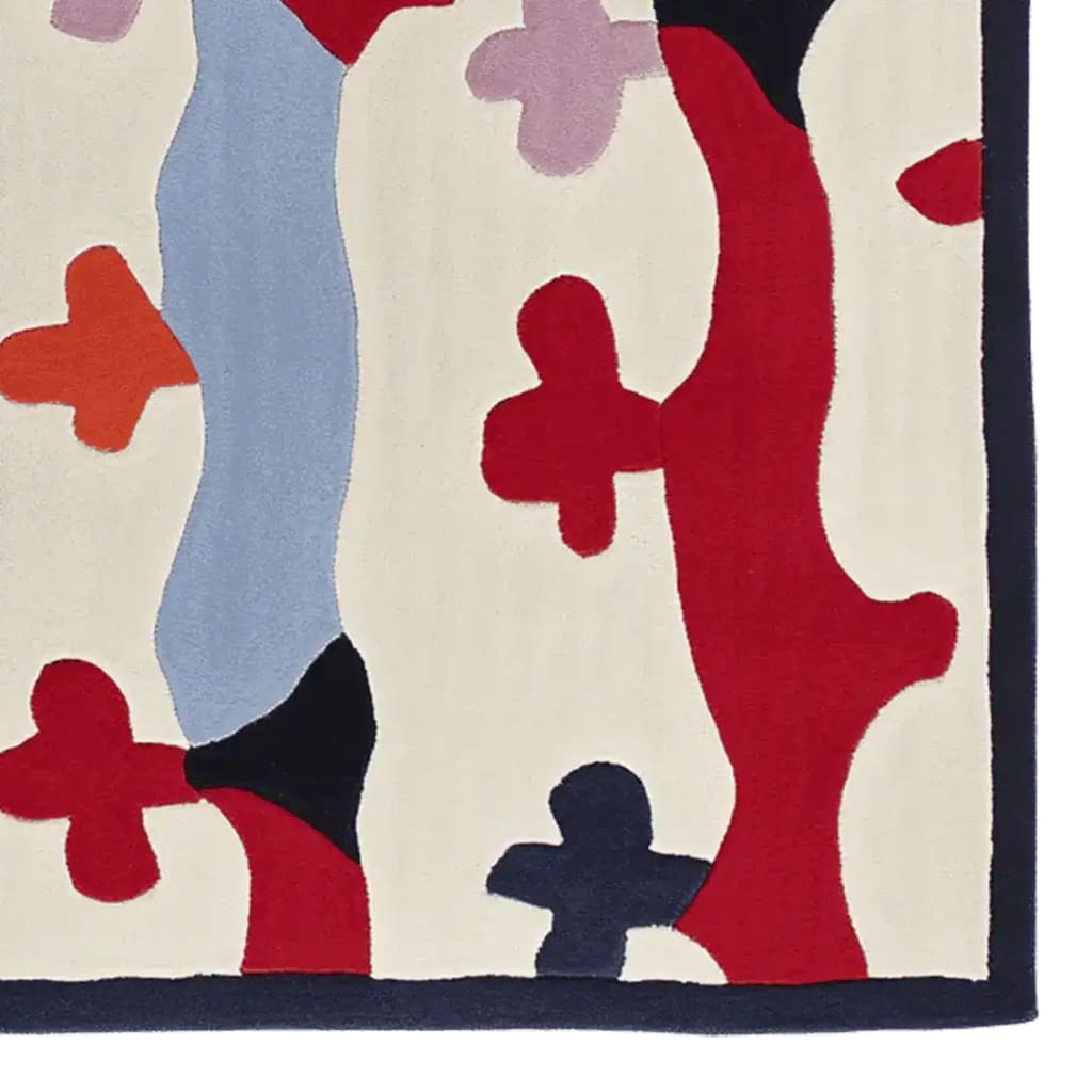 A vibrant hand-tufted area rug with an abstract design featuring bold colors like red, blue, and orange on a cream background. Perfect for adding a contemporary touch to living room spaces, this wool rug offers a unique blend of style and comfort.