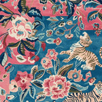 A vibrant and artistic area rug featuring a hand-tufted design with a playful tiger and floral pattern. This wool rug, perfect for a living room, showcases a bold mix of pink and blue hues, making it an eye-catching square area rug for any space.