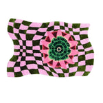 A vibrant hand-tufted wool area rug featuring a wavy checker pattern in green and pink with a bold floral design in the center. This contemporary boho rug is perfect for adding a unique touch to living room decor, combining modern artistry with cozy comfort.