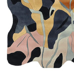 Top view of the Wild Grove Ember Hand Tufted Rug, a contemporary area rug featuring an abstract design with flowing patterns in black, beige, pink, and mustard. Perfect as a wool rug for large living room spaces, enhancing the decor with its intricate detailing.