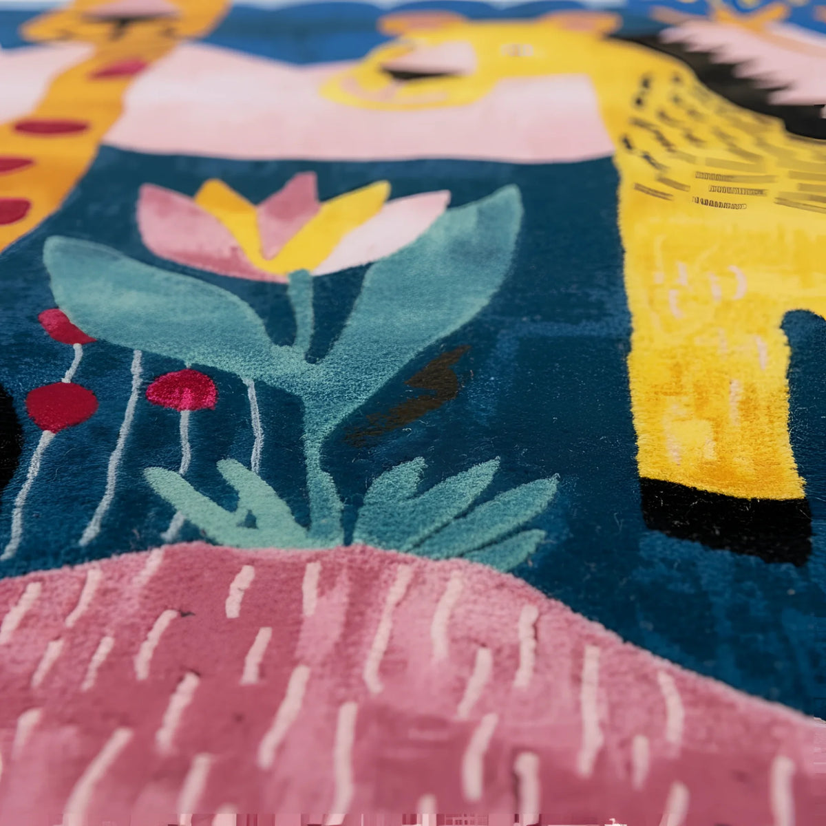 Close-up of a colorful rug with floral patterns and a person wearing a yellow shirt.