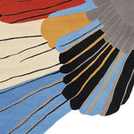 Close-up of the Winged Motion Form Hand Tufted Rug showcasing its vibrant colors and abstract design. This contemporary square area rug, perfect for large living rooms, features bold hues of red, blue, black, and beige, highlighting its wool texture. Ideal for those seeking a unique wool rug for their living space.