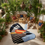Colorful feather-shaped rug on a patio with plants and furniture