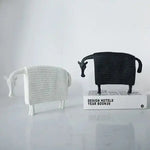 Pair of winter horse sculptures in white and black woven texture finish, standing on marble surface, front view