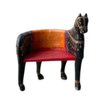 Left side view of wooden horse Maharaja chair, black carved wood with gold harness, curved orange back, red seat