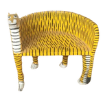 Left side view of yellow wooden tiger Maharaja chair with carved tiger head, black stripe pattern and white paws