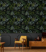 Yellow chair and wood credenza against enigmatic leafy canopy wallpaper of dark foliage