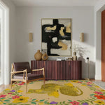 A stylish area rug featuring a vibrant yellow cheetah design surrounded by colorful floral patterns, ideal for enhancing the modern decor of an office or dining room. This hand-tufted wool rug adds a touch of elegance and warmth, perfectly complementing the contemporary furniture and abstract wall art in the room.