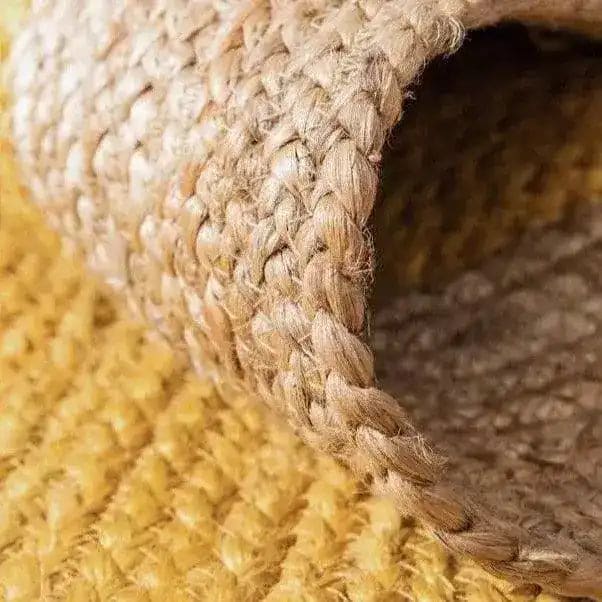 Close-up view of a yellow oval jute area rug, showcasing its intricate weave and natural texture, perfect for adding a boho touch to large living rooms.