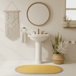 Bathroom interior with a sink, mirror, a yellow jute rug, and decorative elements.