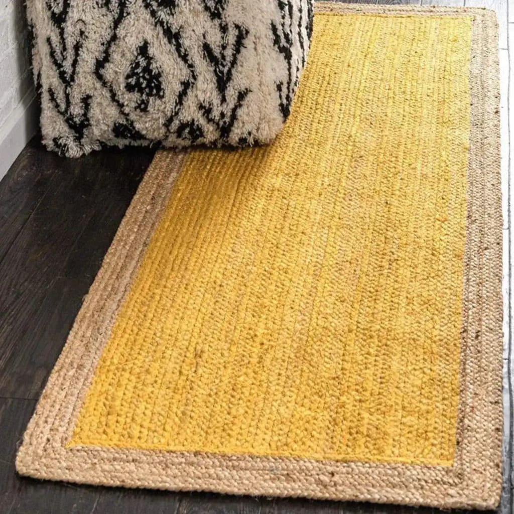 A vibrant yellow rectangular jute rug placed on a dark wooden floor, ideal for adding a boho touch to bedroom decor. The area rug features a natural jute border, making it a perfect choice for those seeking stylish rugs for the bedroom.