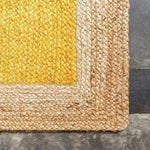 Close-up view of a yellow rectangular jute rug, perfect for adding a boho touch to your bedroom. This area rug features a vibrant yellow center with natural jute braiding around the edges, making it an ideal choice for rugs for bedroom spaces.