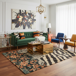 Modern living room with a green sofa, colorful rug, and abstract painting.
