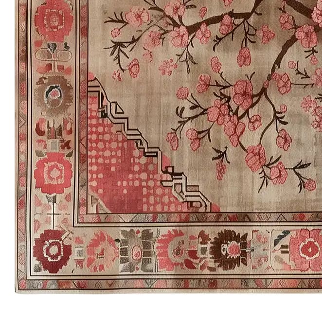 A beautifully detailed Zen Blooms Hand Tufted Wool Rug featuring an intricate floral pattern with pink blossoms against a soft beige background. Perfect for adding a touch of elegance to living room spaces, this area rug measures 8x10 and offers the warmth and softness of a wool rug.