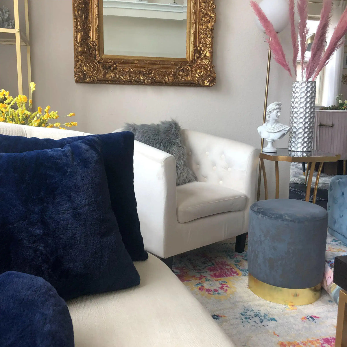White Apollo Belvedere bust on a gold table styling a living room with navy and grey accents