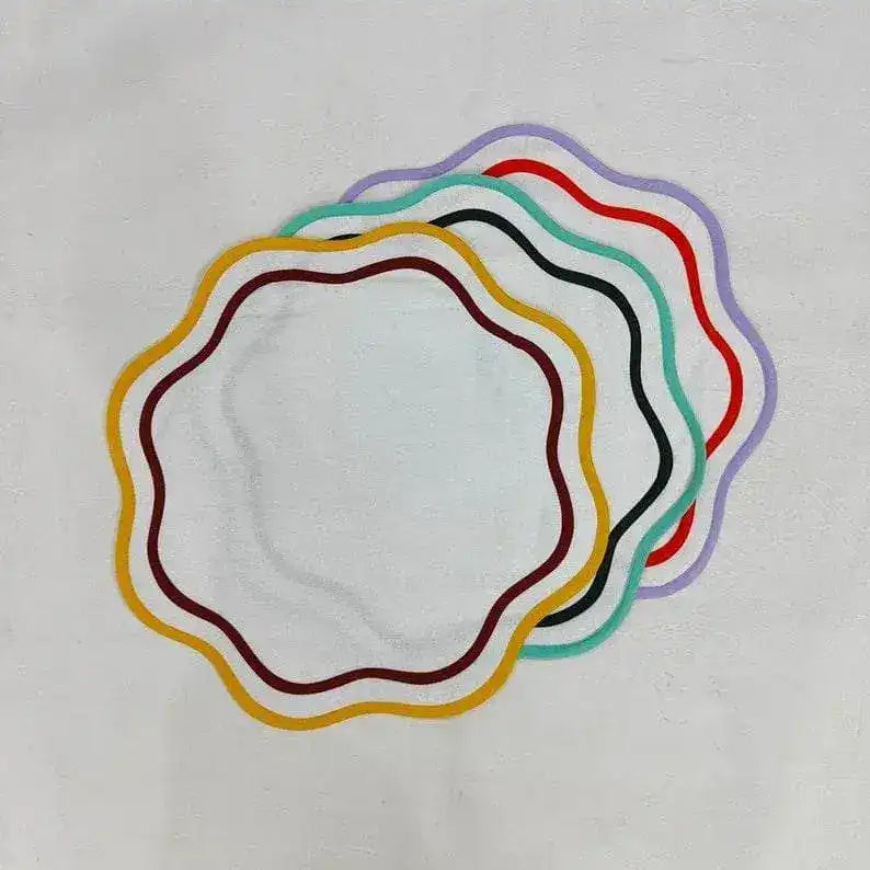 Five double trim scalloped round placemats fanned showing yellow, black, teal, red, and purple wavy edges