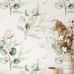 Green Eucalyptus and Roses Leaves and Branches Watercolor Botanical Wallpaper installed on a wall beside a vase of dried cotton and pampas grass