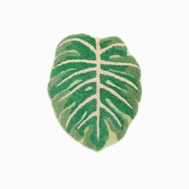 A vibrant green leaf-shaped decorative bathroom mat made from soft cotton, ideal as a runner rug in the kitchen or hallway. The intricate design resembles a tropical leaf, adding a refreshing touch to any bathroom decor.