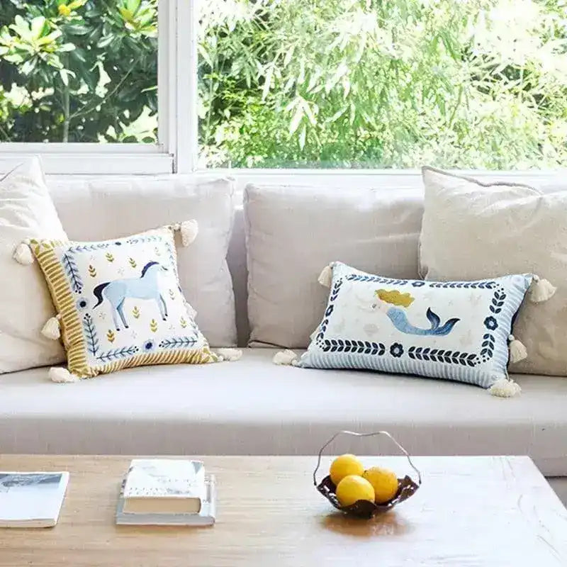 Hand painted throw pillow featuring a mermaid and unicorn design, fringed edges, perfect for adding a whimsical touch to home decor.