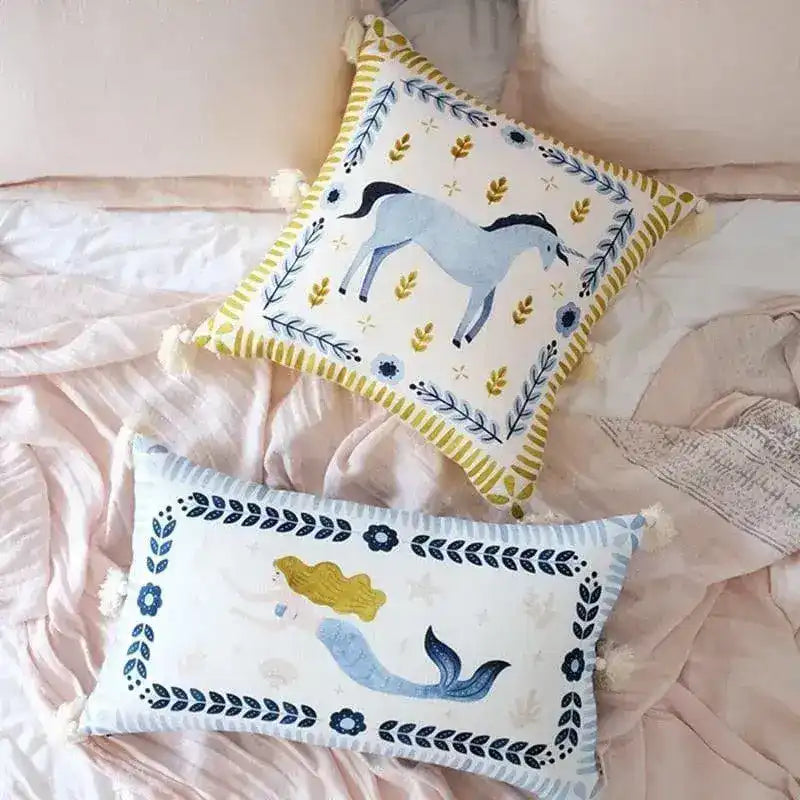 Hand-painted throw pillow featuring a unicorn and mermaid design, fringed edges, perfect for whimsical home décor.