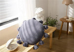 Round decorative throw pillow with tassels, perfect for adding style and comfort to your living space.