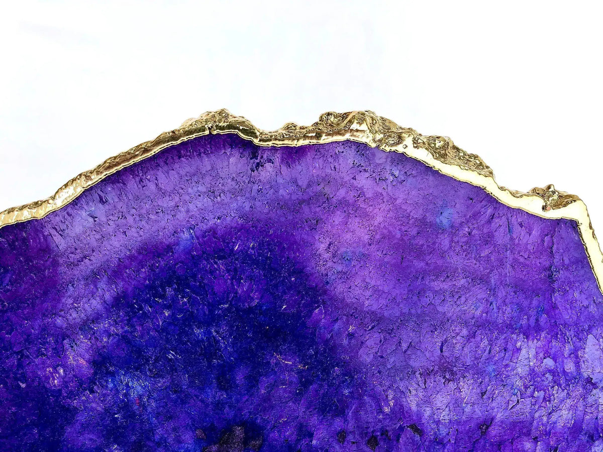 Upper edge close-up of small purple agate table, top third of vibrant violet-purple agate slab and molten gold lava-textured rim